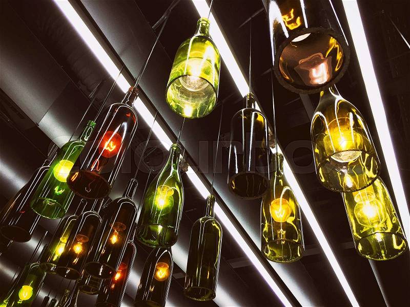 Magnificent retro light lamps decoration made of wine bottles. Toned, stock photo