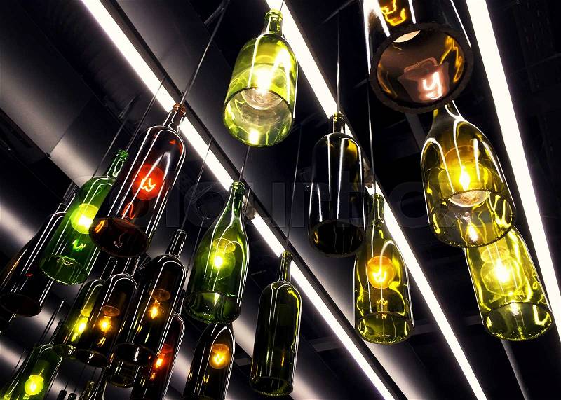Magnificent retro light lamp decoration made of wine bottles. Toned, stock photo