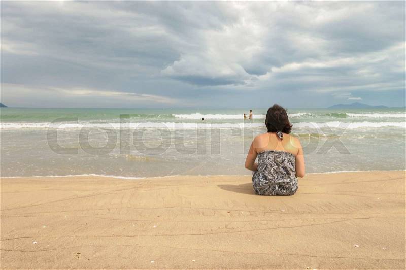Woman looking at the sea at the China Beach in Danang, Vietnam, stock photo