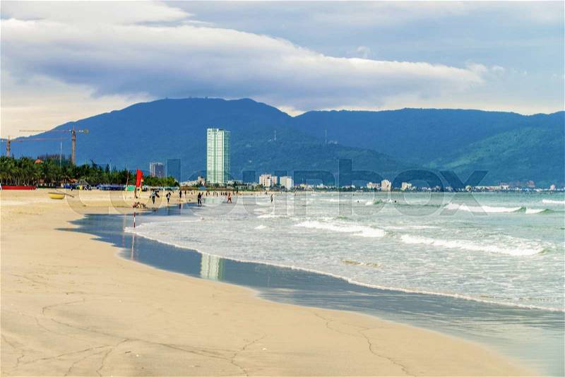 People and China Beach in Danang in Vietnam. It is also called Non Nuoc Beach. South China Sea and Marble Mountains on the background, stock photo
