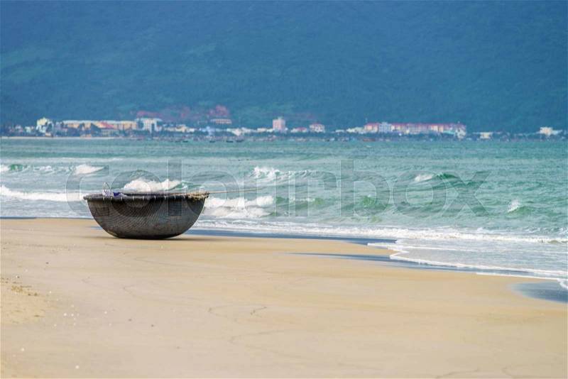 Bamboo waterproof round fishing boat at the China Beach in Danang in Vietnam. It is also called Non Nuoc Beach. South China Sea on the background, stock photo