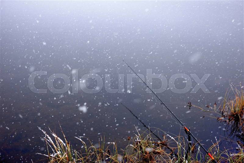 Autumn fishing under snowfall on the lake, stock photo