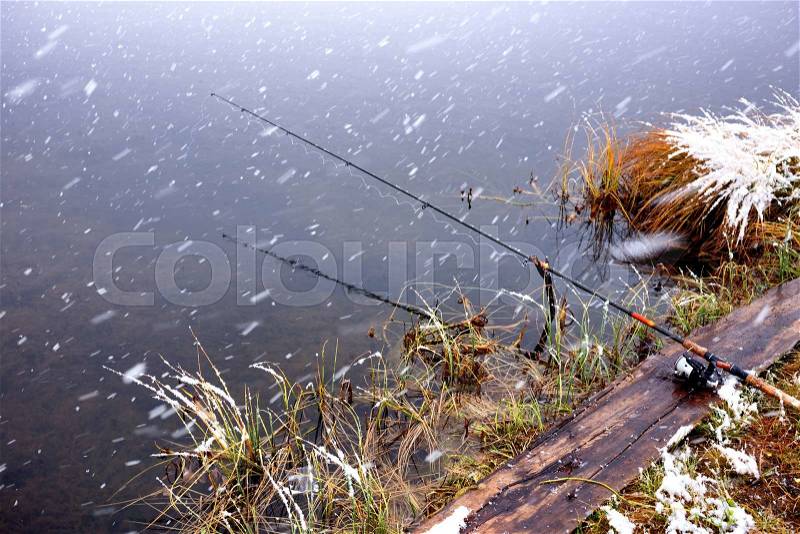 Autumn fishing under snowfall on the lake, stock photo