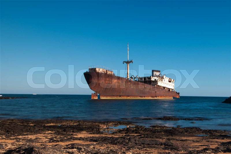 Old rusty boat stranded on the shore in Lanzarote, Canary Islands, Spain, stock photo