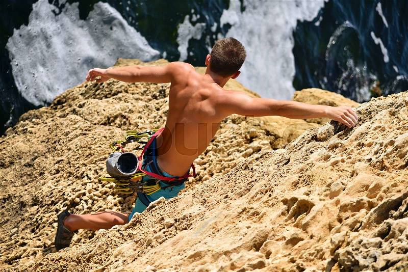 Extreme climber man caught on a rock, view from above, stock photo
