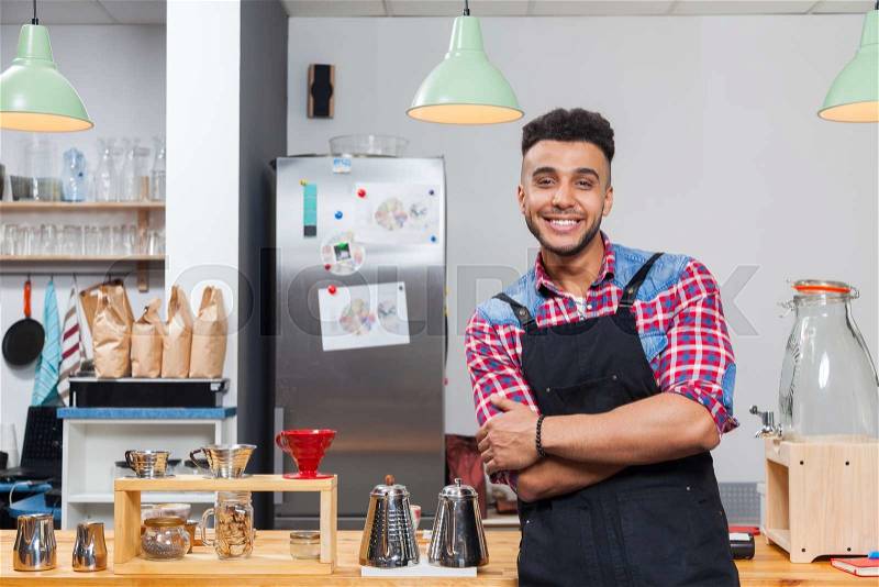 Barista coffee shop owner handsome man happy smile sitting on bar counter small business, stock photo