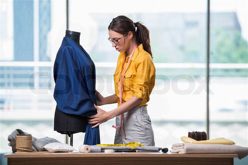 Woman tailor working on new clothing, stock photo