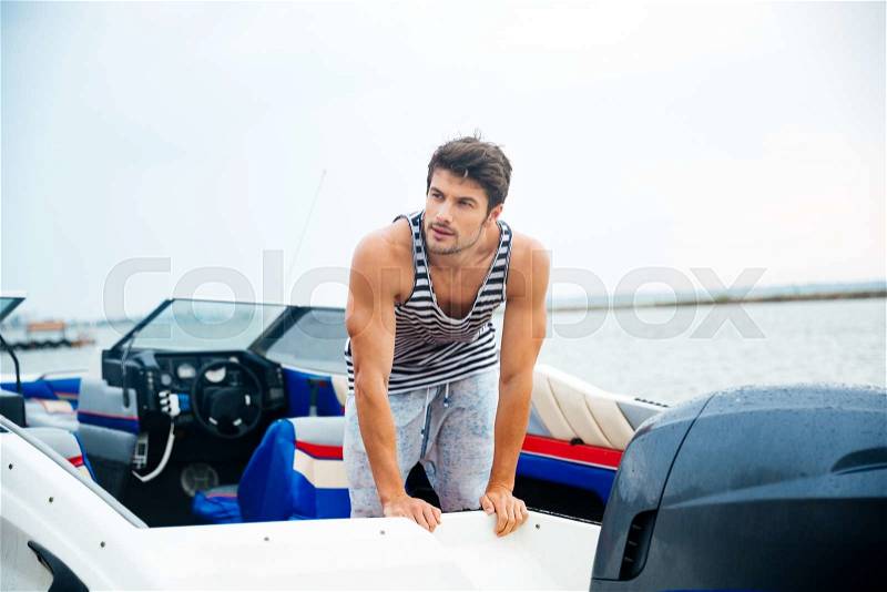 Young sailor man in his motor boat, stock photo