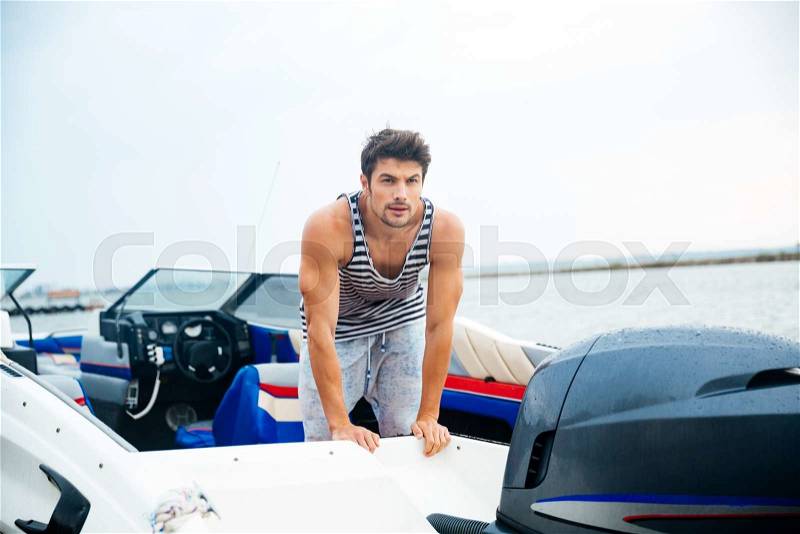 Young sailor man in his motor boat, stock photo