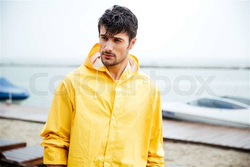 Portrait of a sailor man in yellow cloak at the pier, stock photo