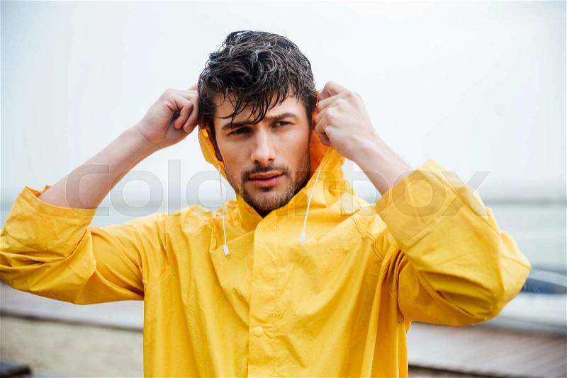 Portrait of a sailor man in yellow cloak at the pier, stock photo