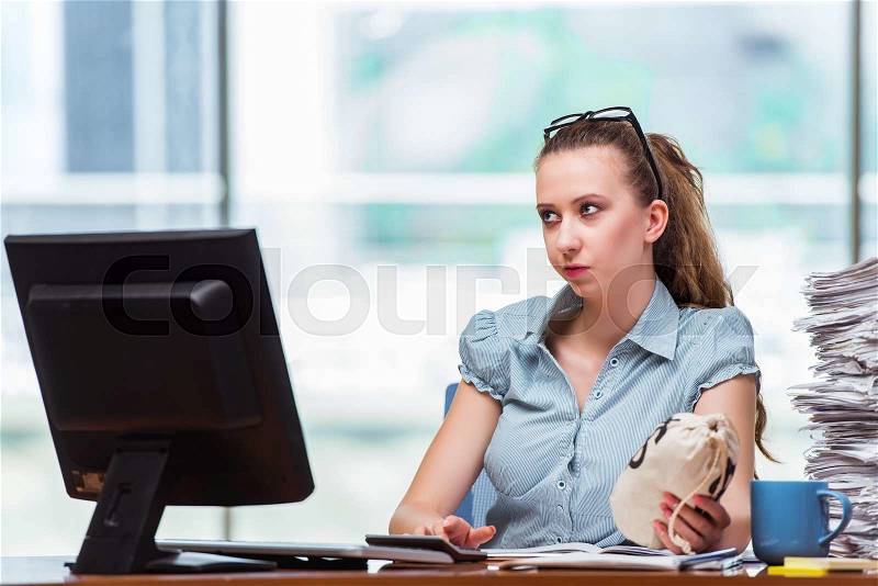 Businesswoman with money sacks in the office, stock photo