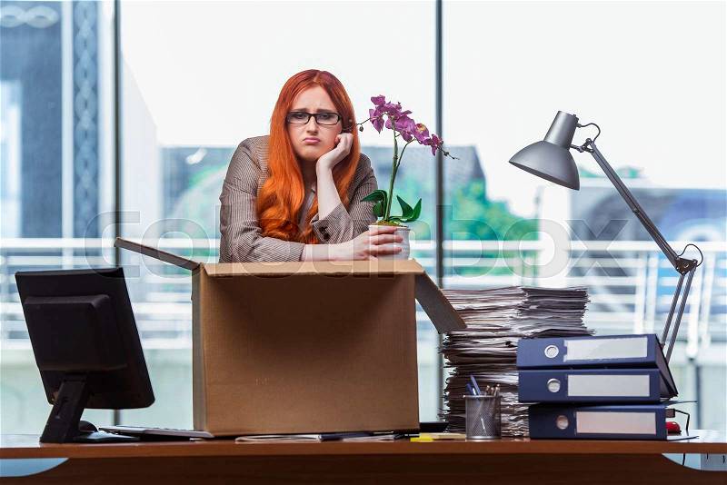 Red head woman moving to new office packing her belongings, stock photo