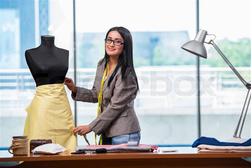 Woman tailor working on new clothing, stock photo