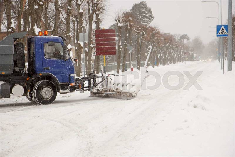 A truck cleaning snow off of the road, stock photo