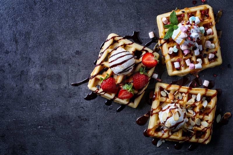 Three various belgian waffles on dark wooden background. From top view, stock photo
