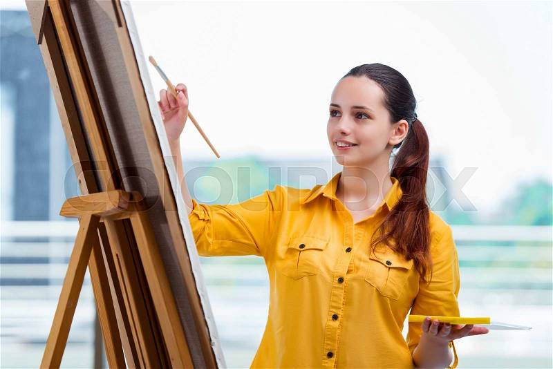 Young student artist drawing pictures in studio, stock photo