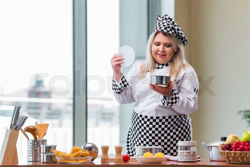 Female cook preparing soup in brightly lit kitchen, stock photo