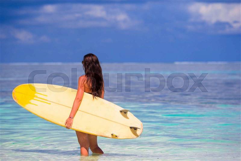 Beautiful surfer woman surfing in turquoise sea, on stand up paddle board at exotic vacation, stock photo