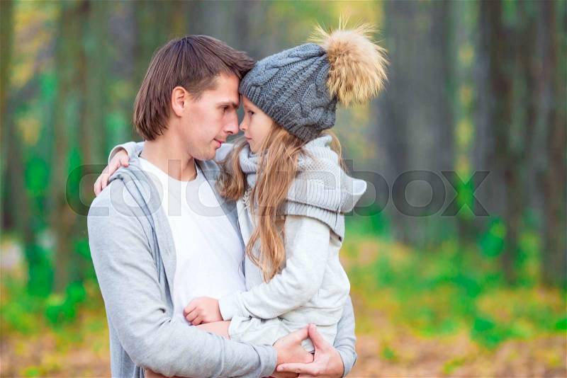 Little adorable girl with happy dad in autumn park outdoors, stock photo