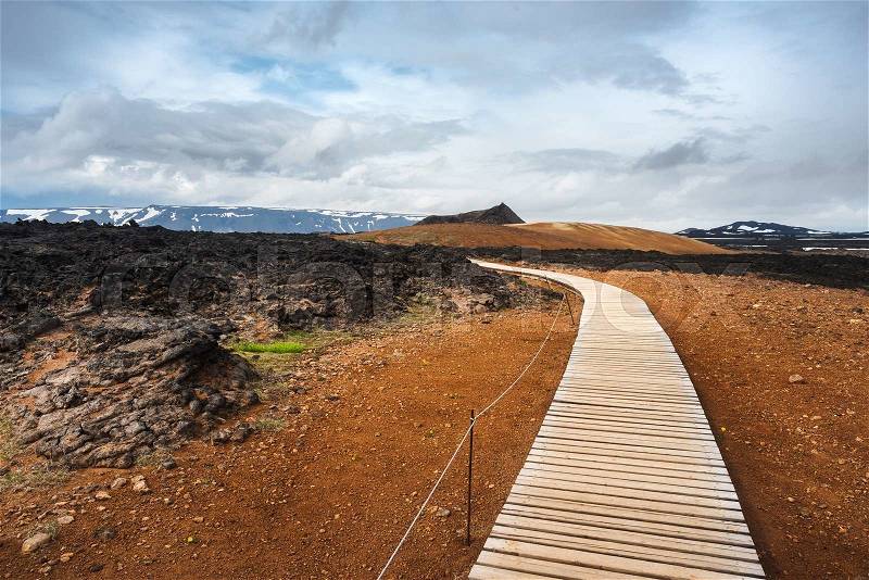 Geothermal area Leirhnjukur. Area Krafla volcano, Iceland, Europe. Tourist trail with wooden planks and fence. Summer landscape a cloudy day, stock photo