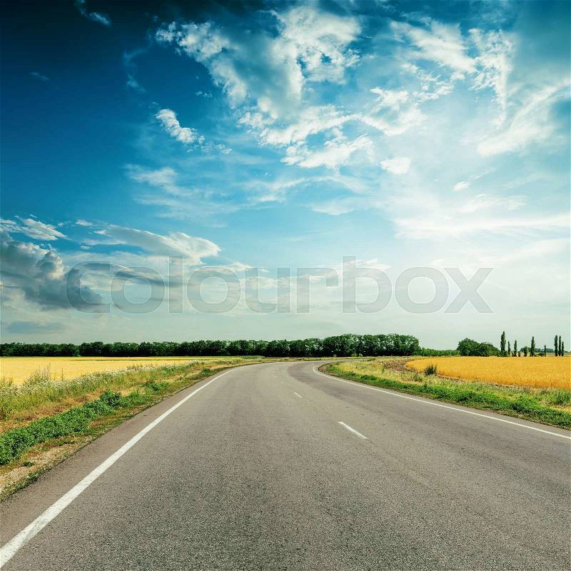 Asphalt road to horizon under dramatic sky, stock photo