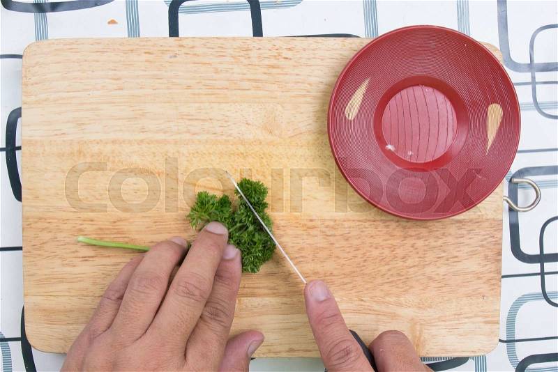 Cutting parsley on a board before cooking / cooking sausage bread concept, stock photo