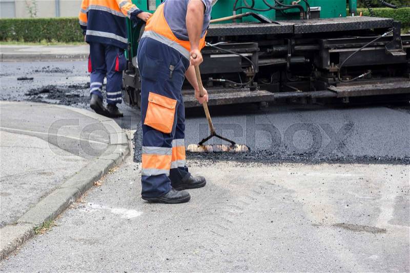 Workers on Asphalting paver machine during Road street repairing works , stock photo
