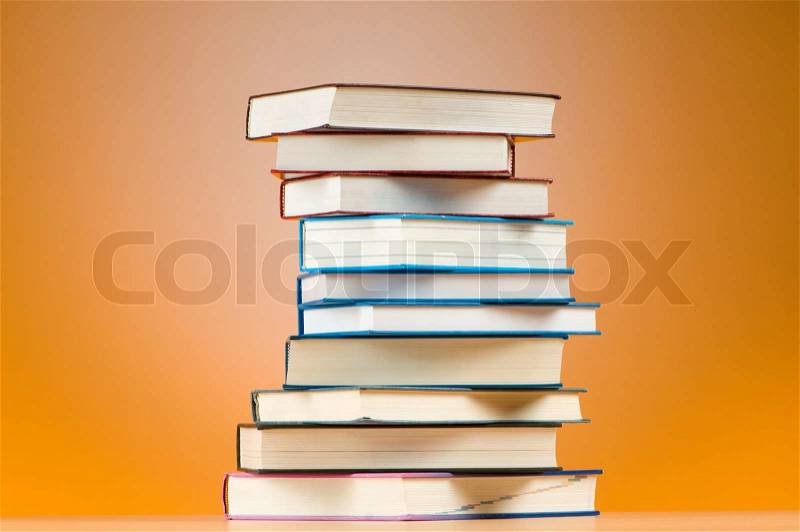 Stack of text books against gradient background, stock photo