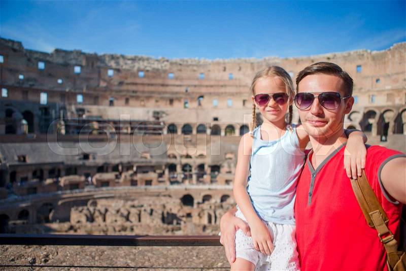 Young father and little girl making selfie in Coliseum, Rome, Italy. Family portrait at famous places in Europe, stock photo