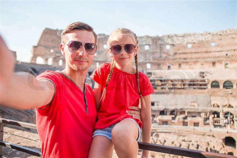 Young father and little girl making selfie in Coliseum, the main tourist attractions of Rome. Family portrait at famous places in Europe, stock photo