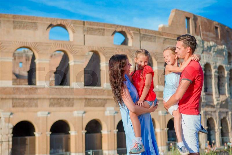 Happy family in Europe. Parents and kids in Rome over Coliseum background. Italian european vacation together, stock photo