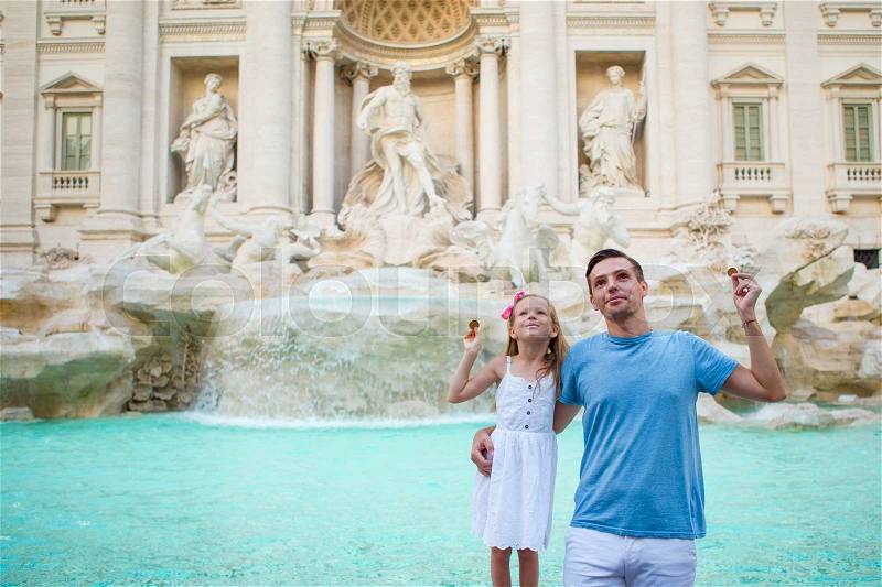 Happy family trowing coins at Trevi Fountain, Rome, Italy for good luck. Happy family enjoy their italian vacation holiday in Europe. Little girl and father making a wish to come back, stock photo