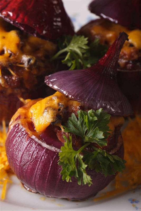 Baked onion stuffed with meat and cheese on a plate macro. vertical\, stock photo