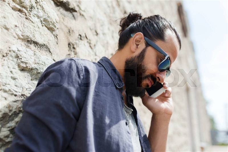 Leisure, technology, communication and people concept - man calling on smartphone on street, stock photo