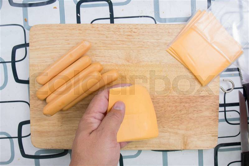 Hands wrap sausage with cheese / cooking sausage bread concept, stock photo
