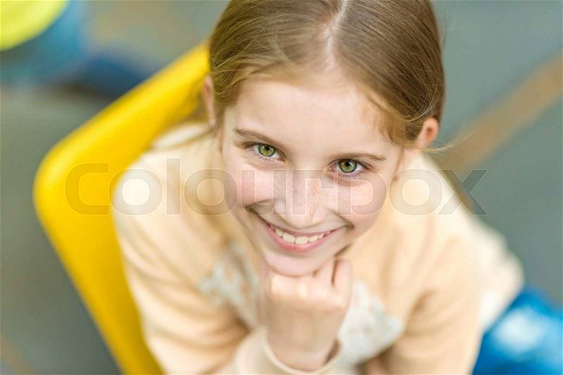 Portrait of beautiful little girl with freckles looking at camera, stock photo