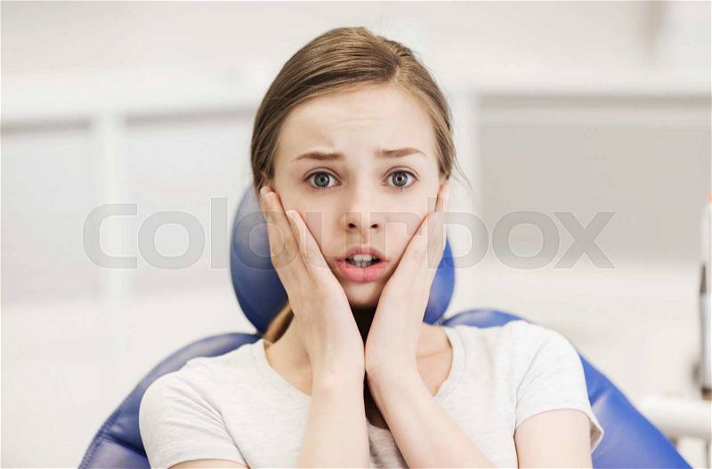 People, medicine, stomatology and phobia concept - scared and terrified patient girl at dental clinic office, stock photo