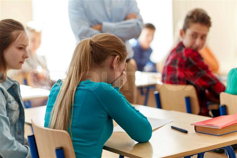 Education, high school, learning and people concept - crying student girl with bad test result and teacher in classroom, stock photo
