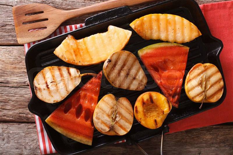 Healthy food: apple, melon, pear, watermelon and peach on a grill pan macro. horizontal view from above , stock photo