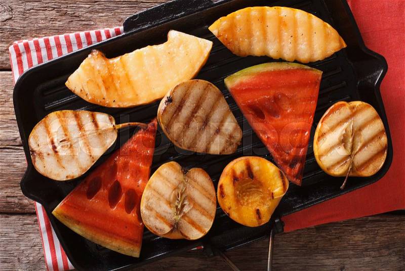 Grilled apple, melon, pear, watermelon and peach on a grill pan closeup. Horizontal view from above , stock photo
