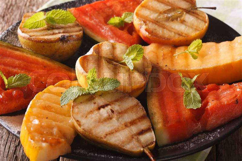 Grilled fruit: watermelon, melon, apple, pear on a plate macro. horizontal , stock photo