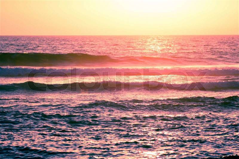 Ocean wave breaking down at sunset time, stock photo