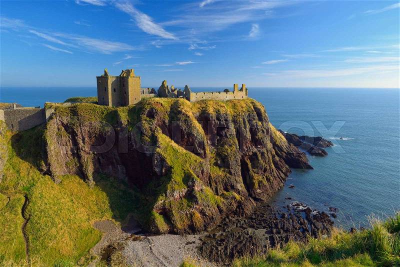 Dunnottar Castle with blue sky background in Aberdeen, Scotland, stock photo