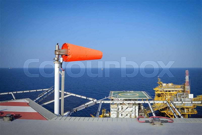 The wind sock is set on the oil rig to showing wind direction for helicopter landing , stock photo