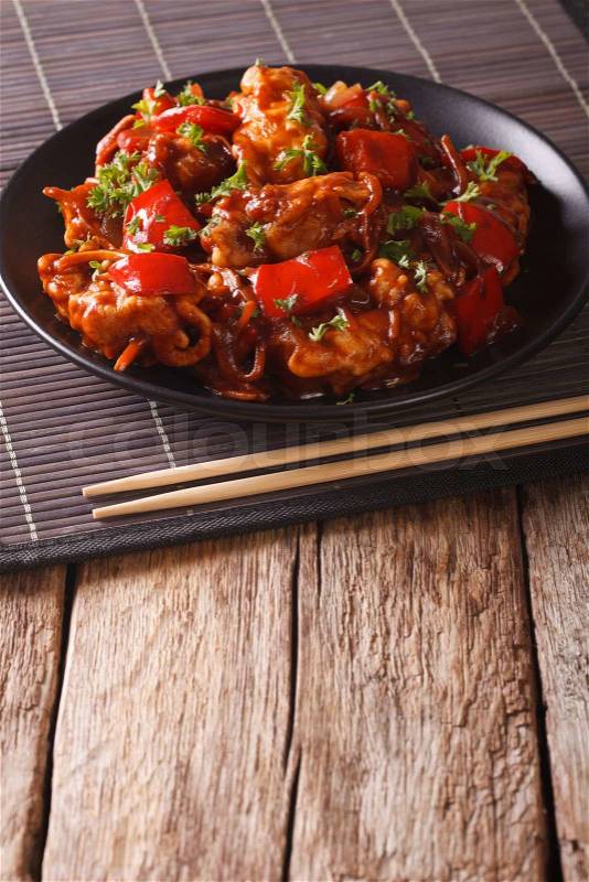 Asian cuisine: Pork with sauce with vegetables on a plate on the table. vertical\, stock photo