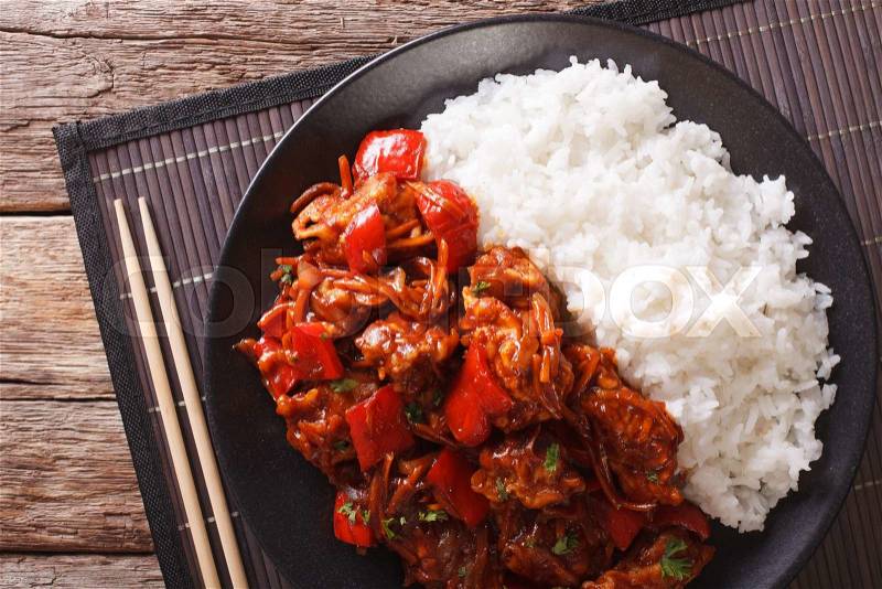 Rice with stewed pork in sweet and sour sauce on the plate closeup. horizontal view from above , stock photo