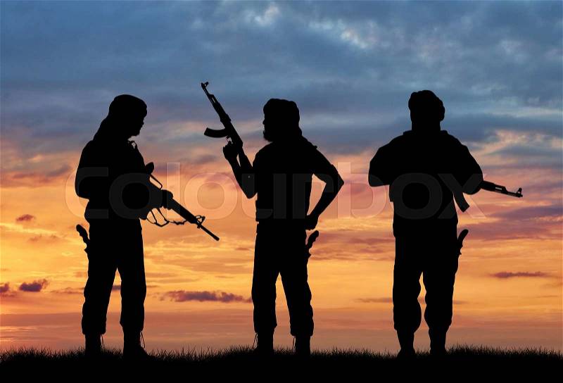 Terrorism and conflict. Armed terrorists on the sunset background, stock photo