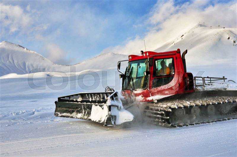 Snowcat rides to work in the evening at sunset, stock photo