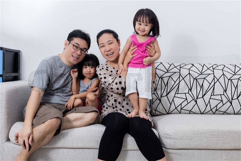 Portrait of Happy Asian Chinese Family Sitting on Couch at Home, stock photo